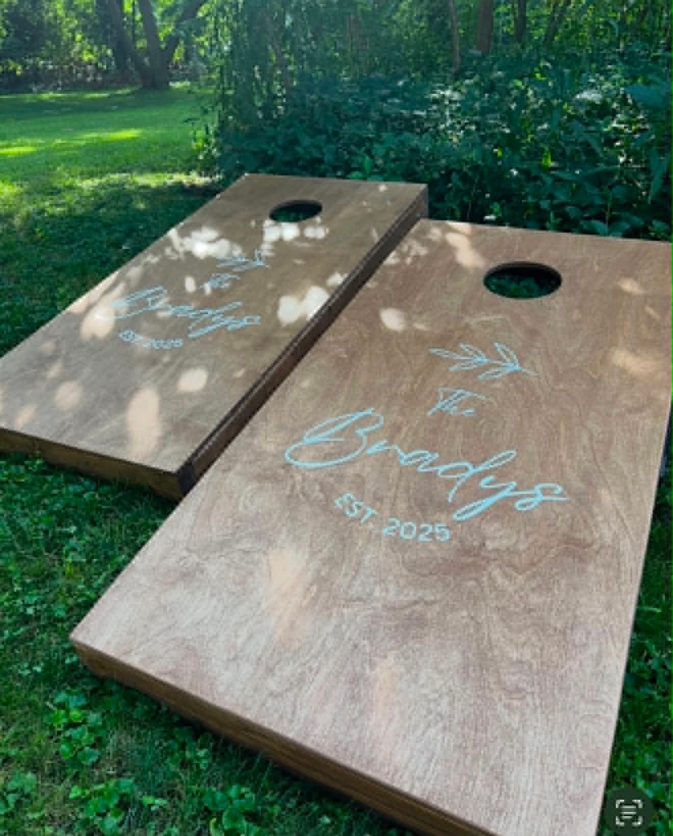 Natural wood cornhole board set reading The Bradys Est. 2025 with a sprig accent
