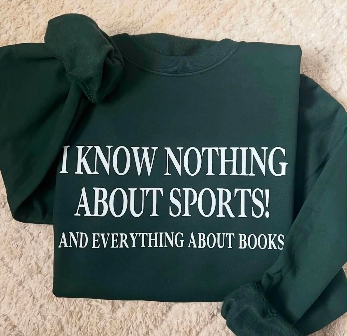 Dark green Gildan crewneck with a direct-to-film print reading I Know Nothing About Sports! And Everything About Books