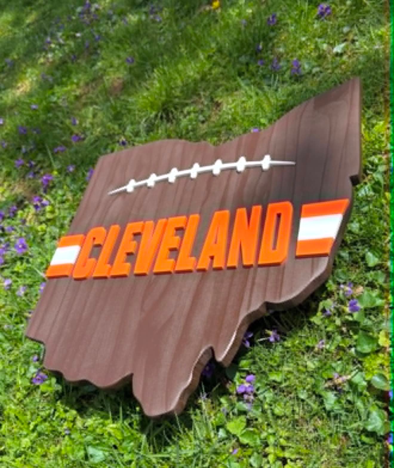 Sign shaped like the state of Ohio with a football design reading Cleveland